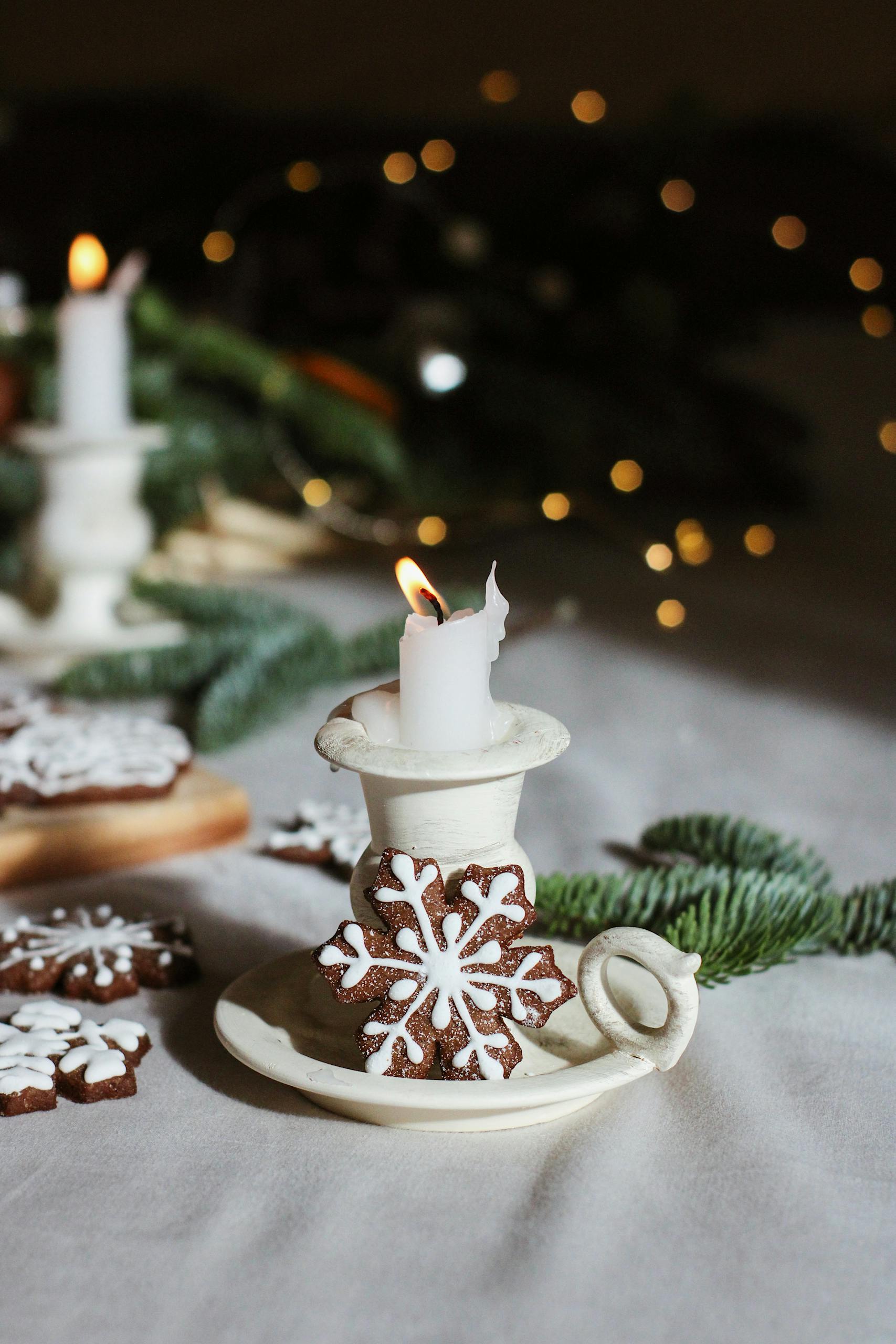 Festive candle with gingerbread and fir decor for a warm holiday feel.